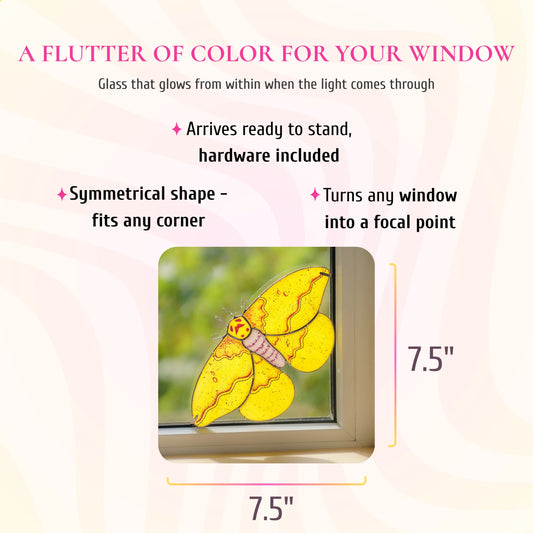 Imperial moth stained glass window corner, 7.5 by 7.5 inches, shown in a window corner. Text: a flutter of color for your window, glass that glows from within when the light comes through. Arrives ready to stand with hardware included, its symmetrical shape fits any corner and turns any window into a focal point.
