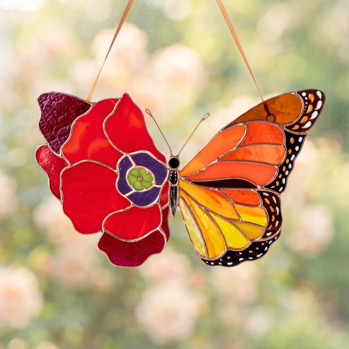 A stunning stained glass butterfly blending a red poppy flower and a monarch wing pattern, hanging against a soft green background.