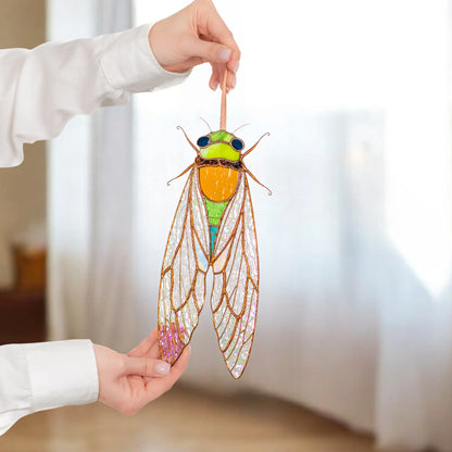 A person holding a handcrafted stained glass cicada, showcasing its vibrant colors and intricate details as a thoughtful gift.