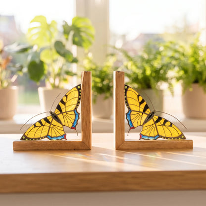 Pair of stained glass swallowtail bookend standing near a sunny window on a shelf