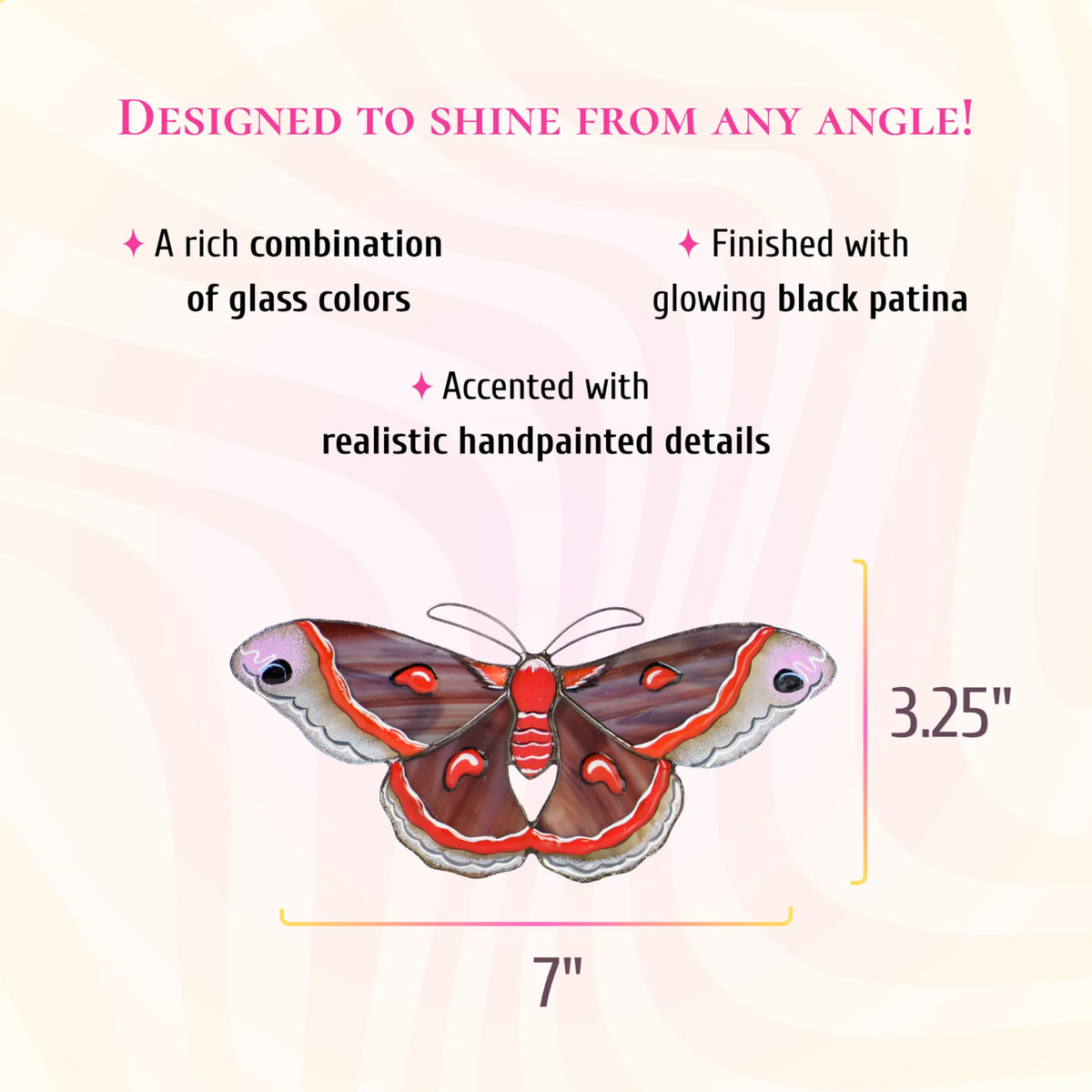 Cecropia moth stained glass suncatcher in plum-brown glass with red bands and red crescent marks, 7 inches wide and 3.25 inches tall. Text: designed to shine from any angle. A rich combination of glass colors, finished with glowing black patina and accented with realistic hand-painted details.