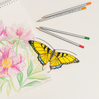 Yellow swallowtail butterfly suncatcher with black stripes and iridescent blue tail edges, on a floral sketchbook