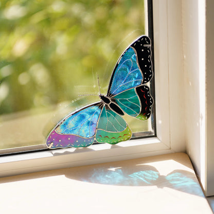 Handmade stained glass morpho butterfly window corner suncatcher casting blue light onto the sill