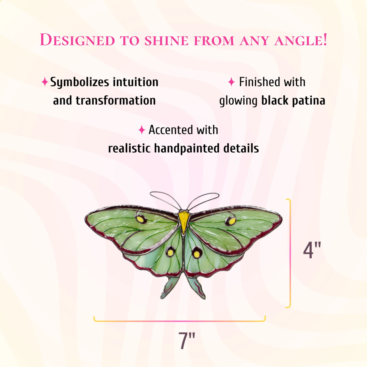 Pale green luna moth stained glass suncatcher with burgundy edges, yellow eyespots and short tails, 7 inches wide and 4 inches tall. Text: designed to shine from any angle. A rich combination of glass textures, finished with glowing black patina and accented with realistic hand-painted details.