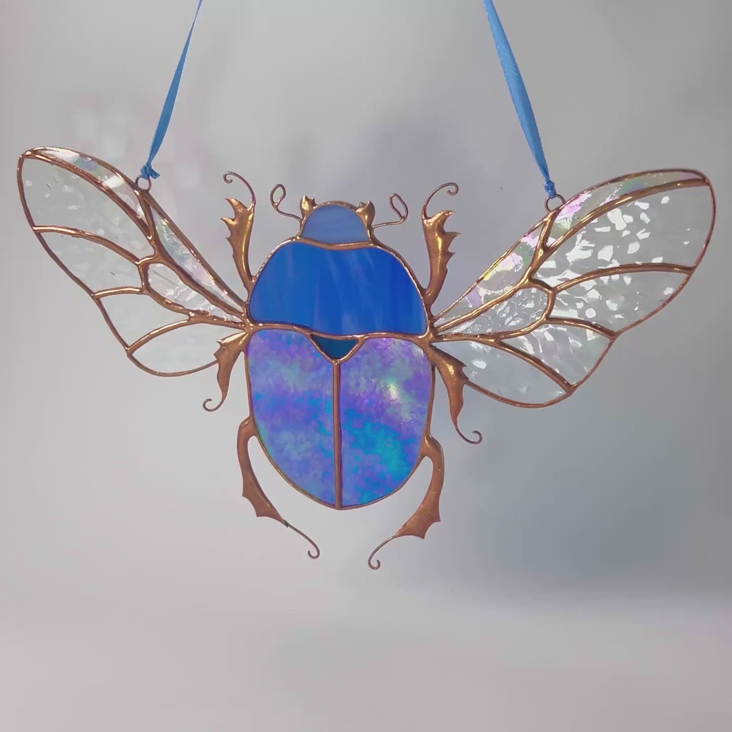 A lovely video highlighting a handcrafted stained glass blue scarab, capturing how it beautifully enhances any shelf or space with its artistic design.