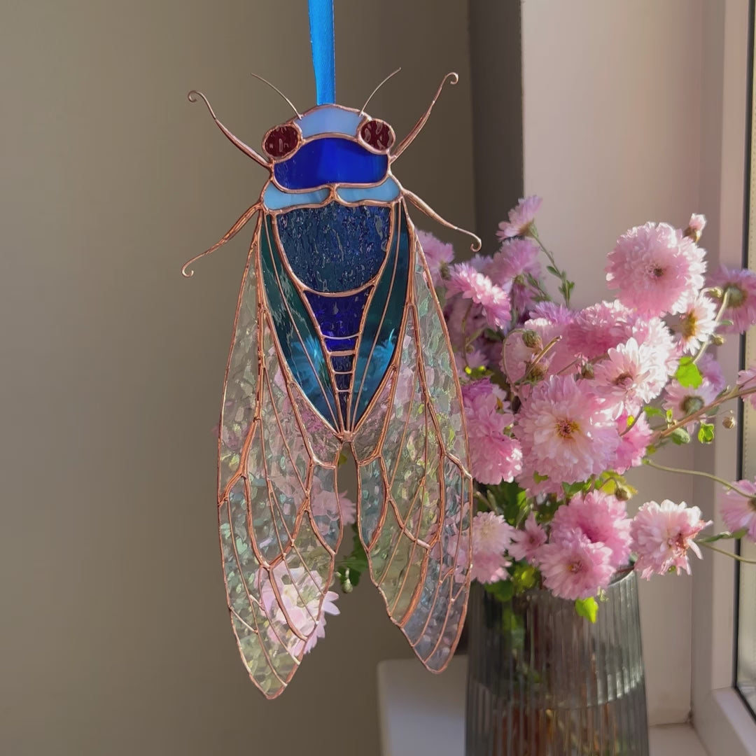 A dynamic video presentation of a versatile stained glass blue cicada suncatcher, showcasing its exceptional craftsmanship and charm as a perfect home decor accent.